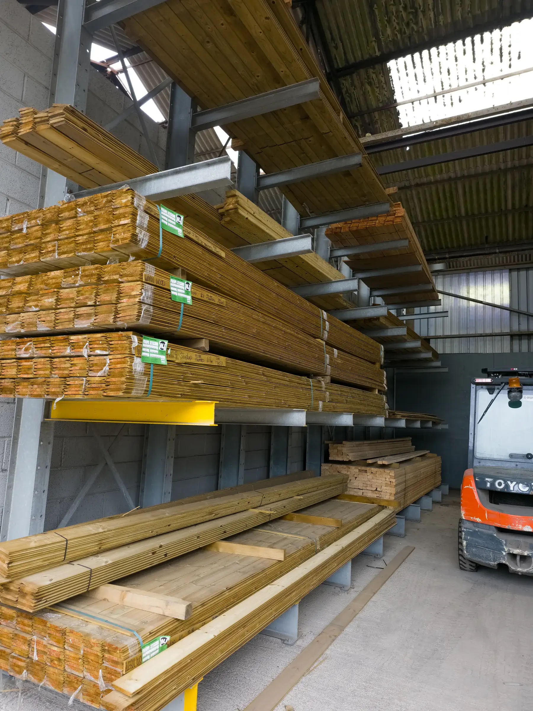 Covered cantilever racking storing timber with a forklift