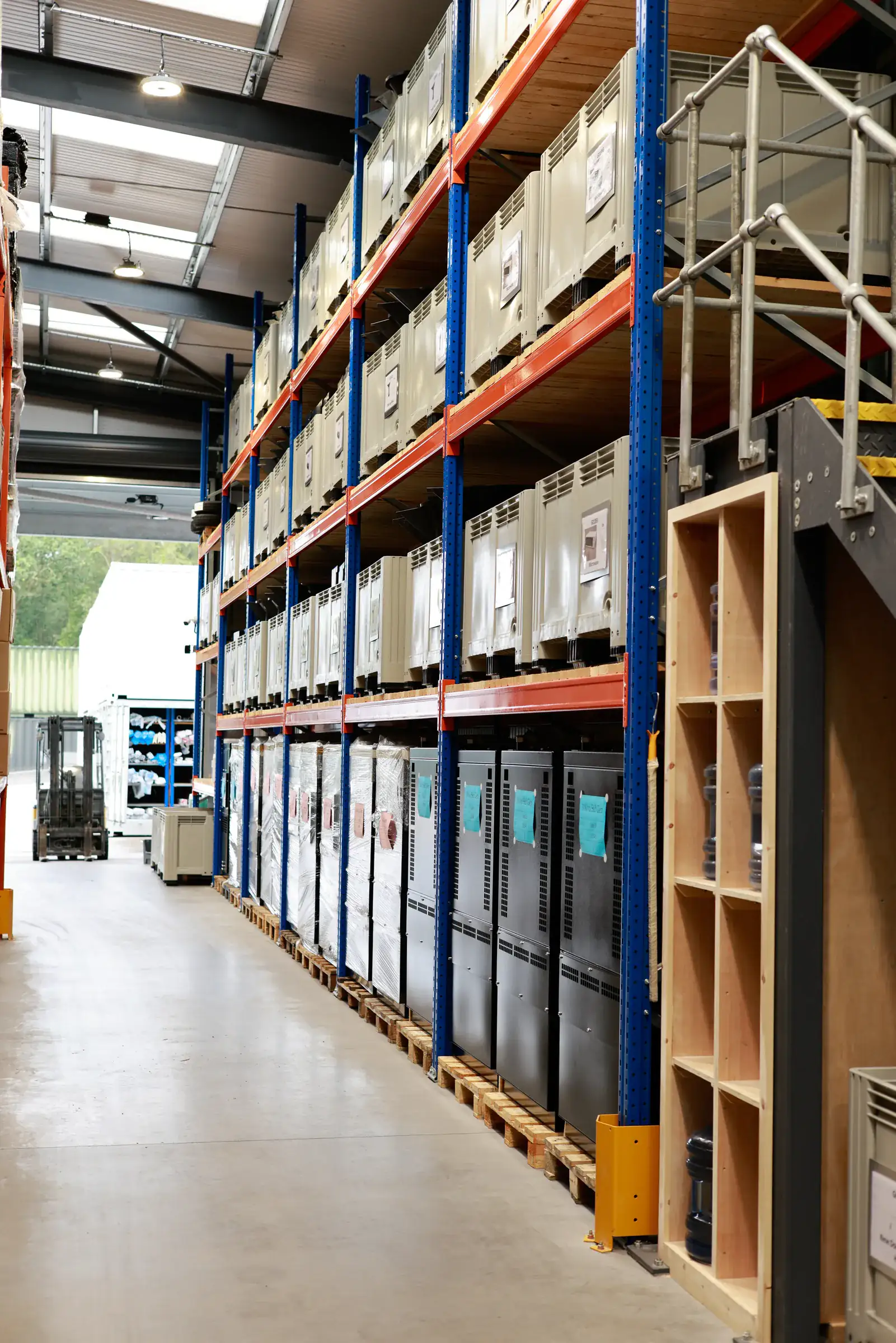 Long aisle of pallet racking with pigeonhole shelving and a forklift