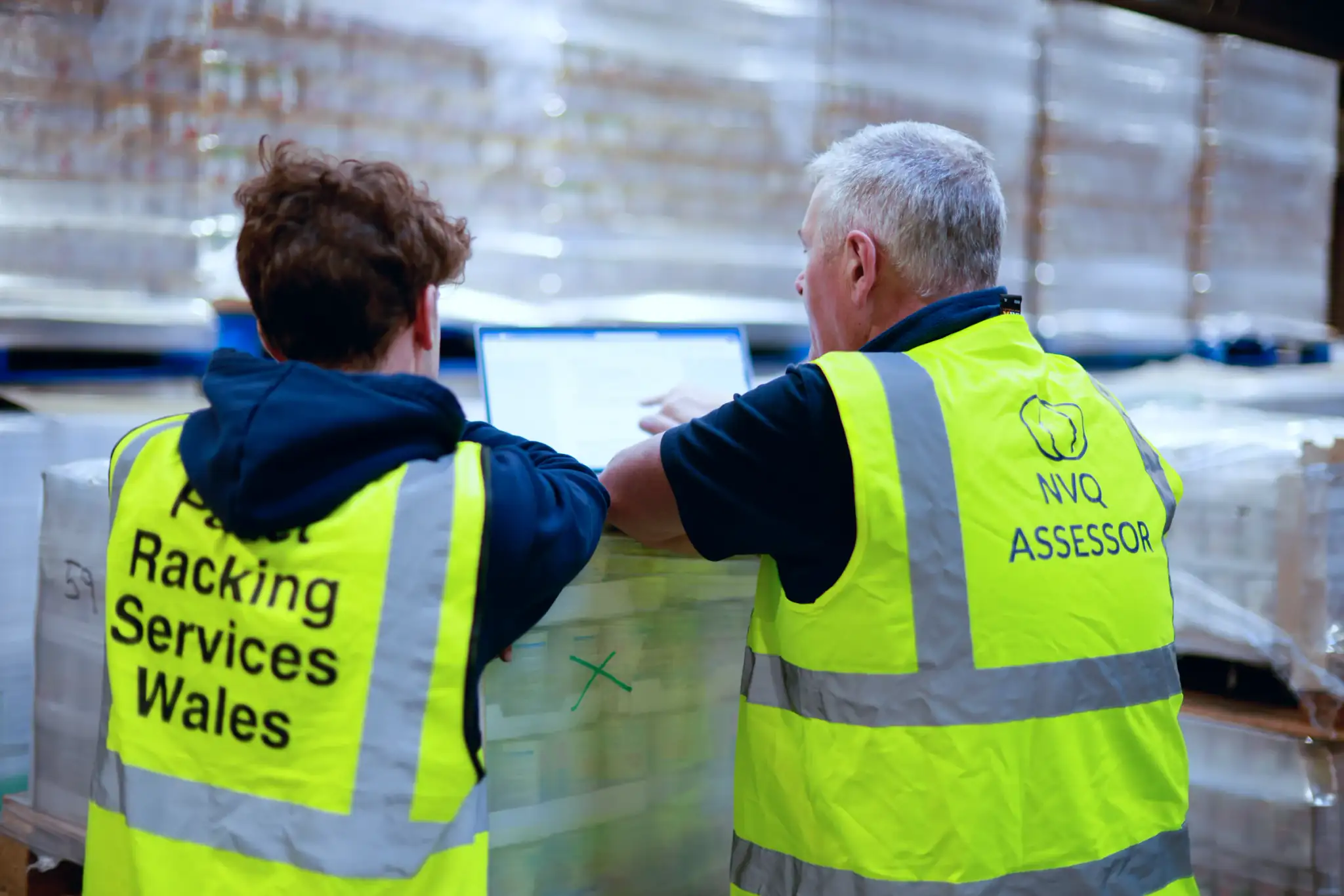 Assessor reviewing work with a racking team member