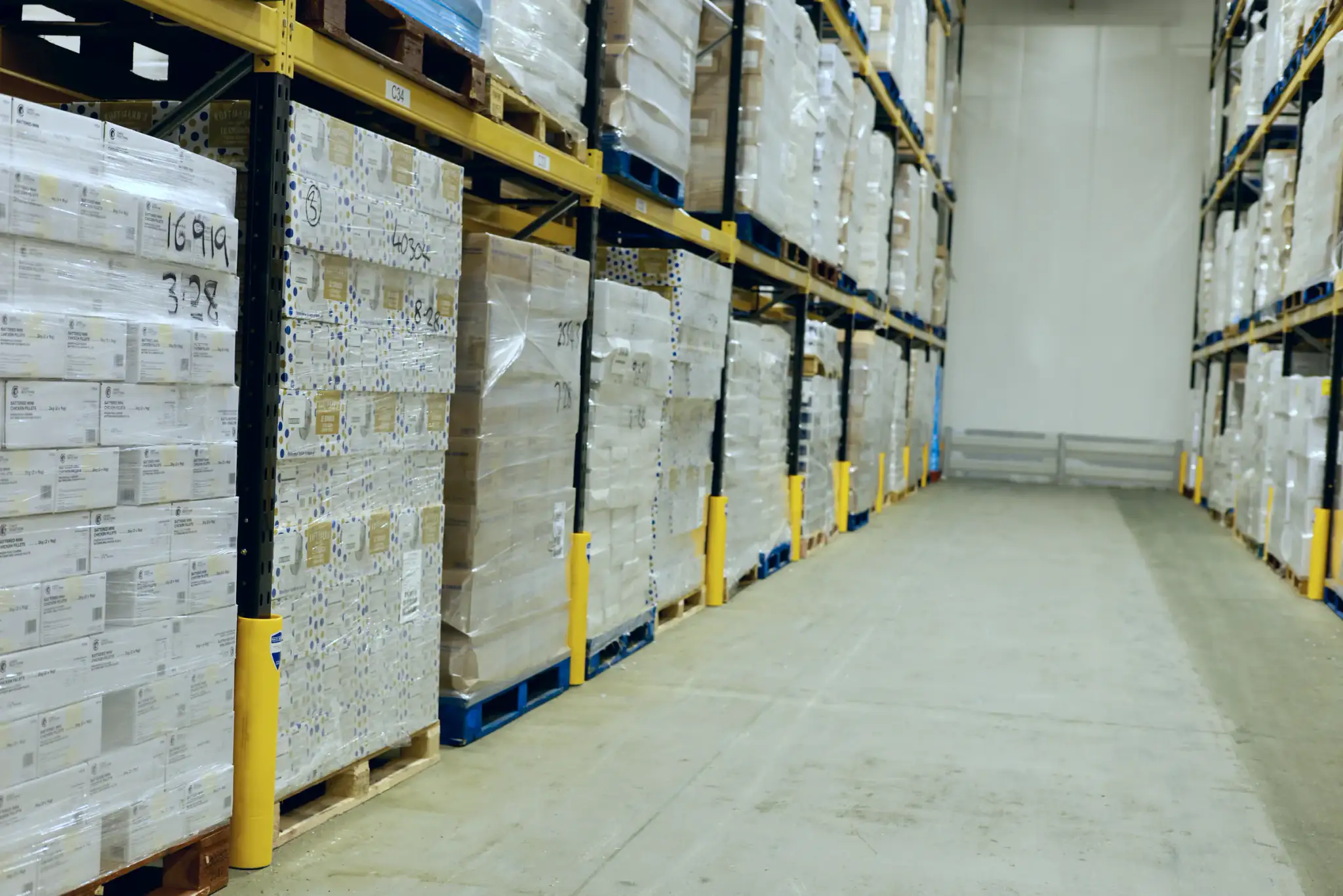 Pallet racking aisle in a cold store with yellow upright protectors