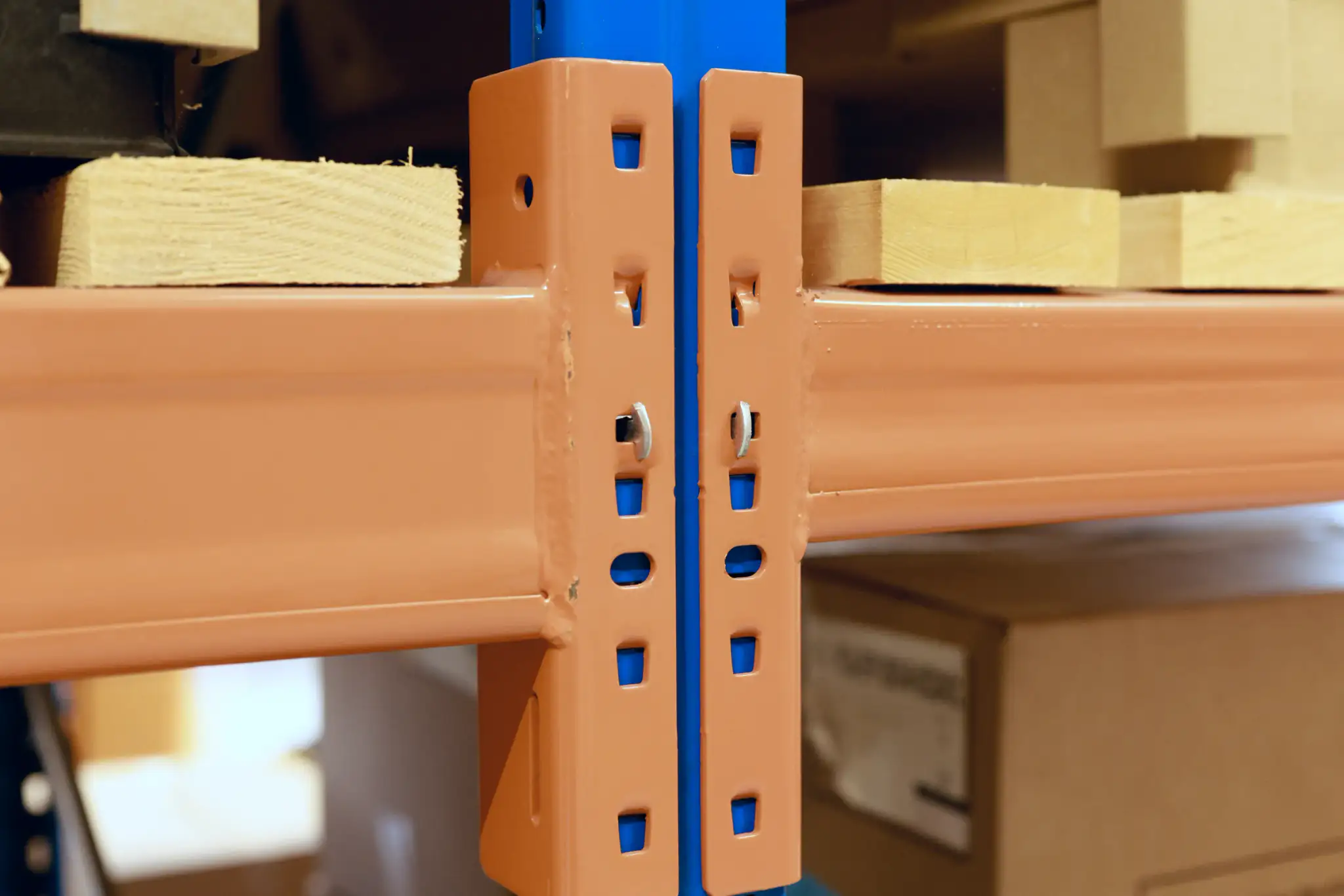 Close up of a pallet racking beam connector with timber decking