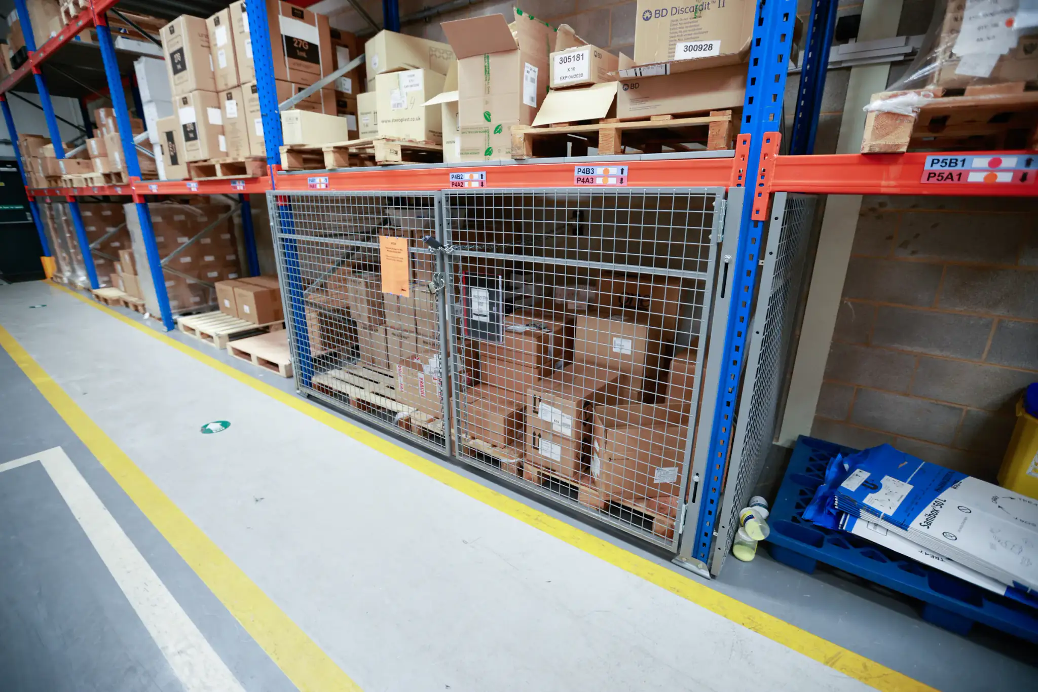 Pallet racking with a mesh security cage and bay location labels